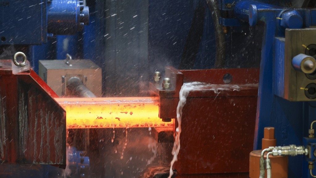 Ein noch glühender Knüppel Stahl fährt in das neue Walzwerk