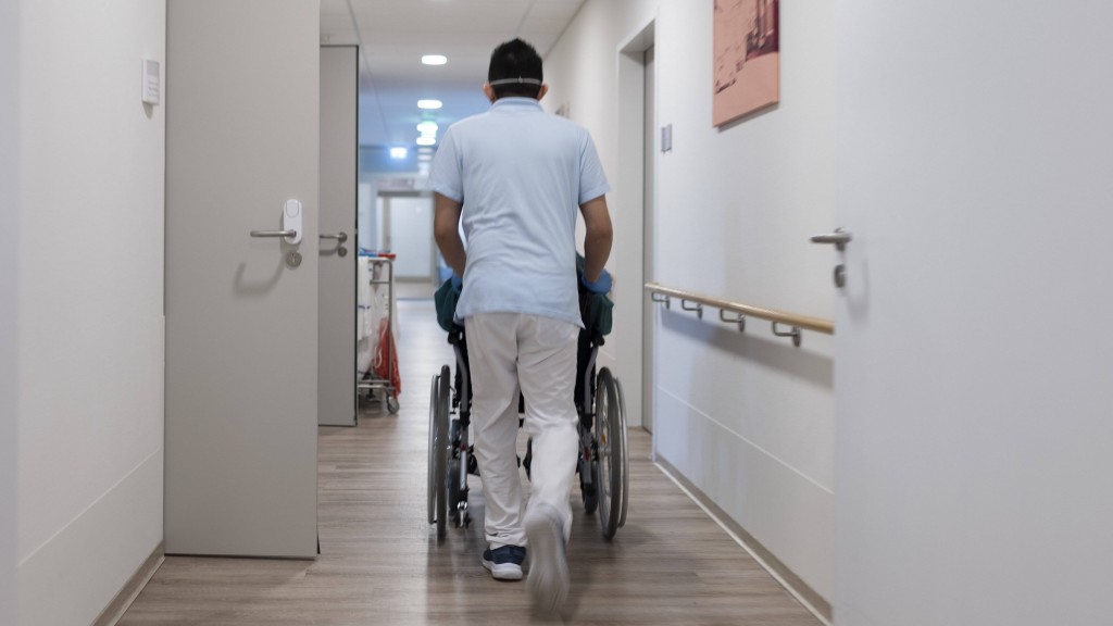 Foto: Pfleger mit Patient im Rollstuhl