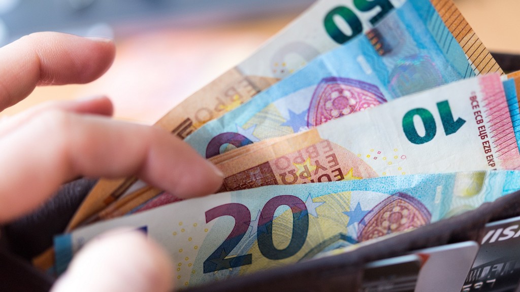 Foto: Eine Frau hält ein Portemonnaie in der Hand, in dem Geldscheine stecken.