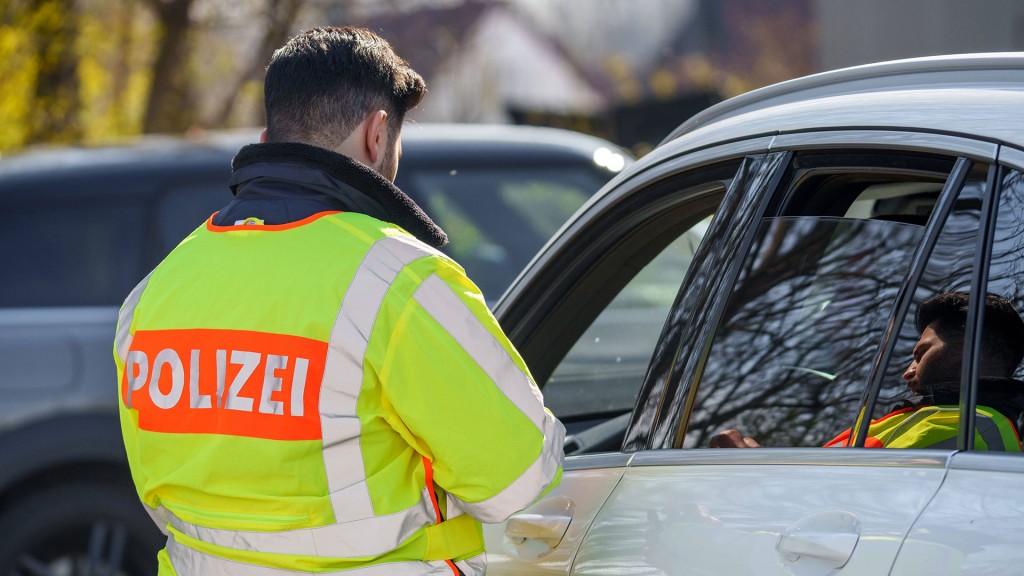 Foto: EIn Polizist steht neben einem Auto und spricht mit dem Fahrer