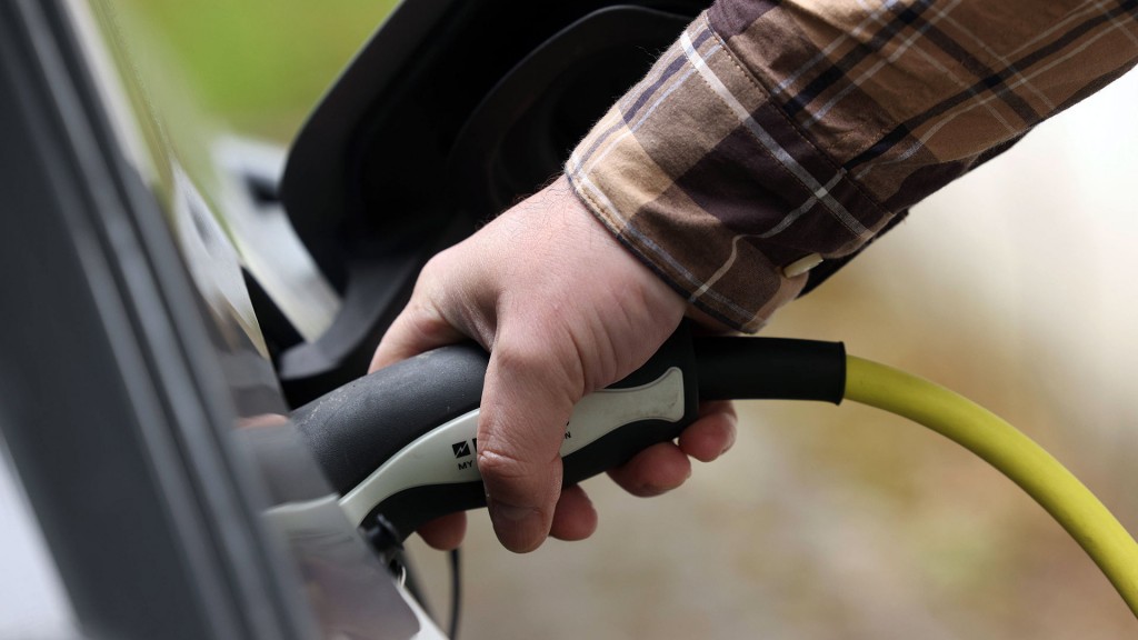 Foto: Hand an dem Stecker eines Elektrofahrzeugs