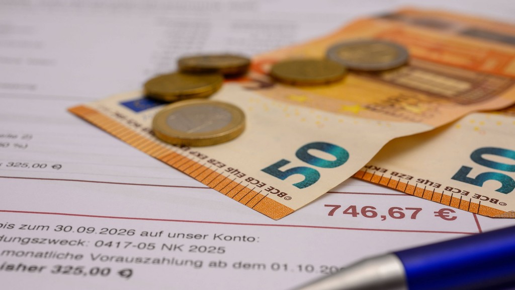 Foto: Geld und Kugelschreiber auf einer Nachzahlung der Nebenkosten