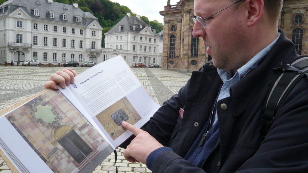 Markus Philipp mit seinem Buch „Saarbrücker Spurensuche“ vor der Saarbrücker Ludwigskirche (Foto: Weitzmann)