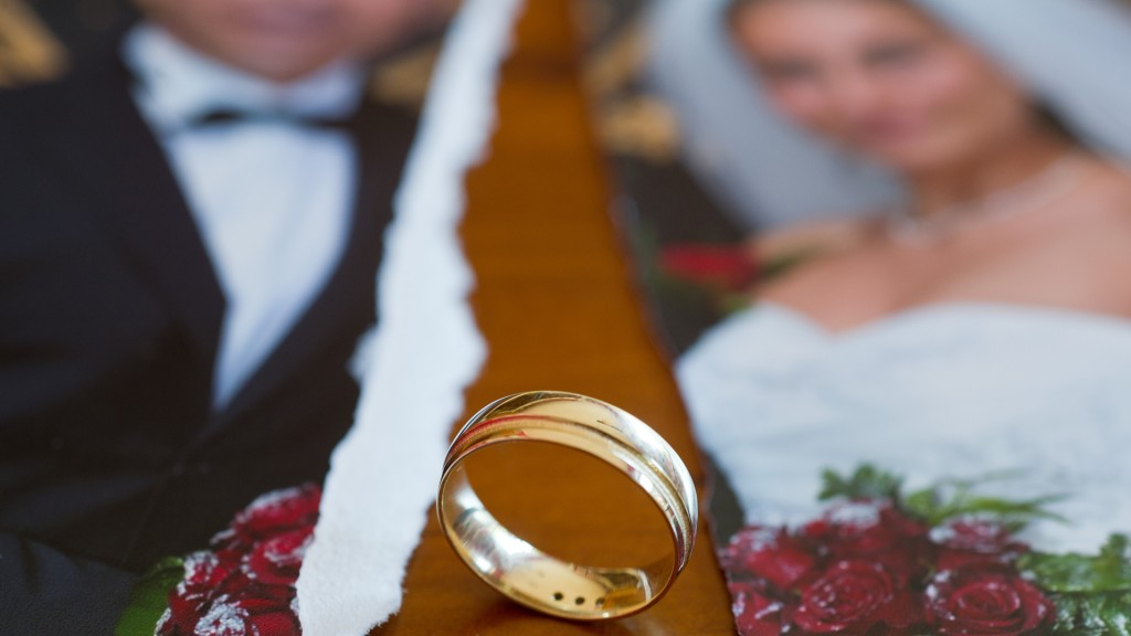 Auf einem Tisch liegen ein zerissenes Hochzeitsfoto und ein Ehering (Foto: picture alliance / dpa)