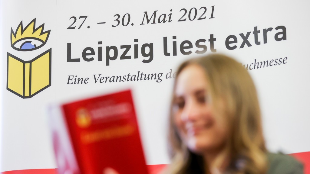 Eine Mitarbeiterin der Leipziger Messe liest im Veranstaltungskatalog zum Lesefest 