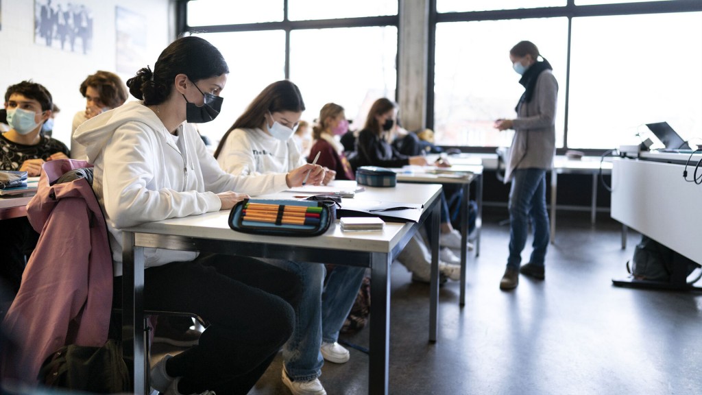 Schülerinnen und Schüler sitzen mit OP-Masken im Unterricht. (Foto: picture alliance/dpa/KEYSTONE | Gaetan Bally)