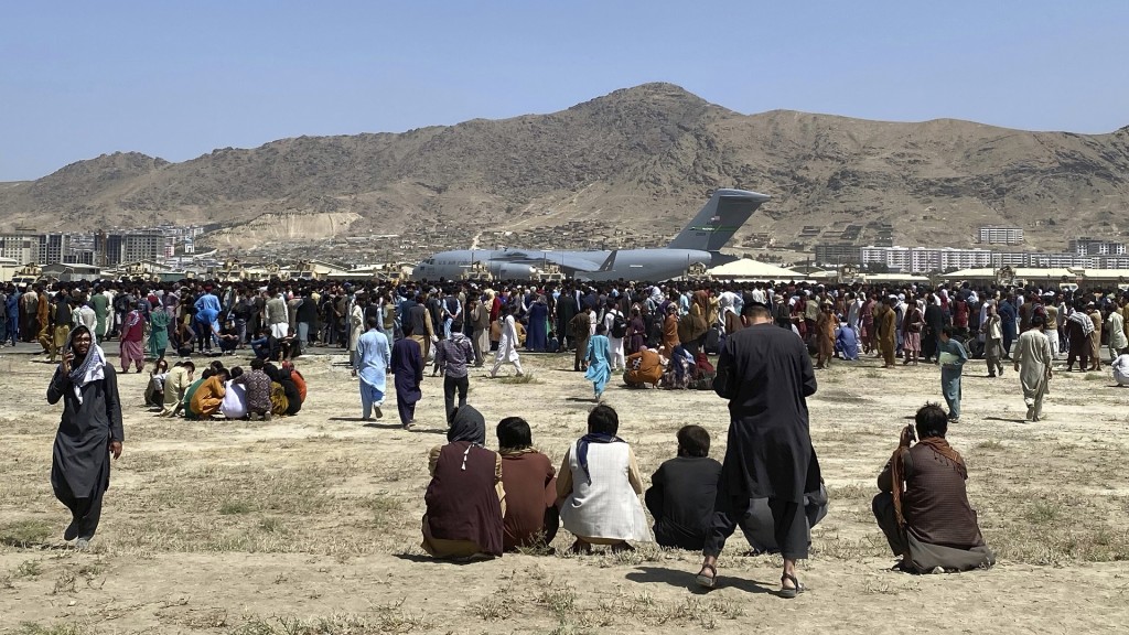 Foto: Hunderte von Menschen versammeln sich in der Nähe eines Transportflugzeugs
