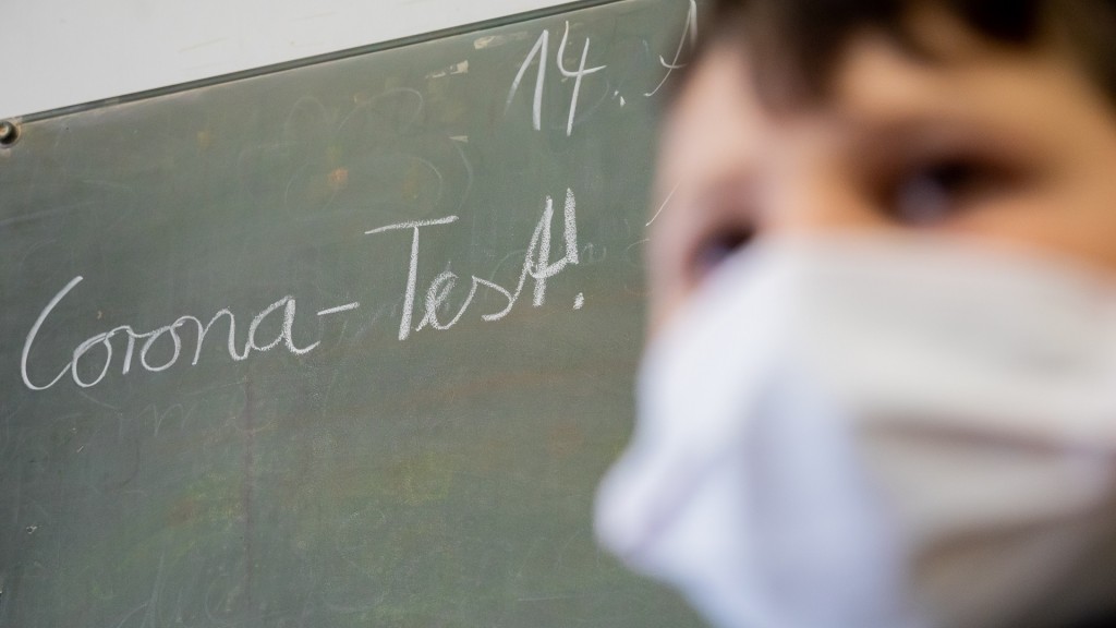 Corona-Test! - Schrift auf Tafel hinter einem Schüler mit Maske. (Foto: picture alliance/dpa | Christoph Soeder)