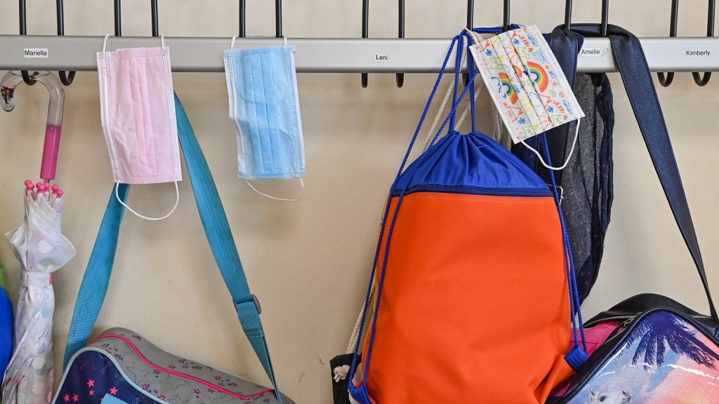 Foto: Schulranzen und Masken hängen an einem Kleiderhaken in einer Schule