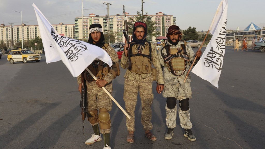 Kabul, 30. August 2021: Drei Kämpfer der Taliban mit Fahnen begrüßen den Truppenabzug der USA (Foto: picture alliance/dpa/AP | Khwaja Tawfiq Sediqi)