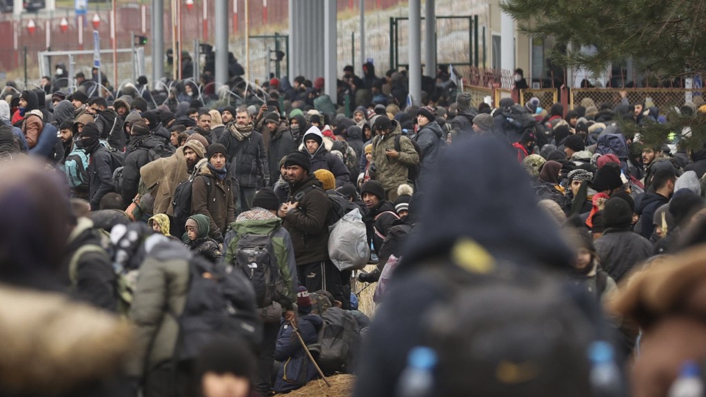 Das von der belarussischen Staatsagentur BelTA via AP zur Verfügung gestellte Handout zeigt Migranten, die sich am Kontrollpunkt Kuznica an der belarussisch-polnischen Grenze versammeln. Die Außenminister der Europäischen Union werden am Montag (15.11.