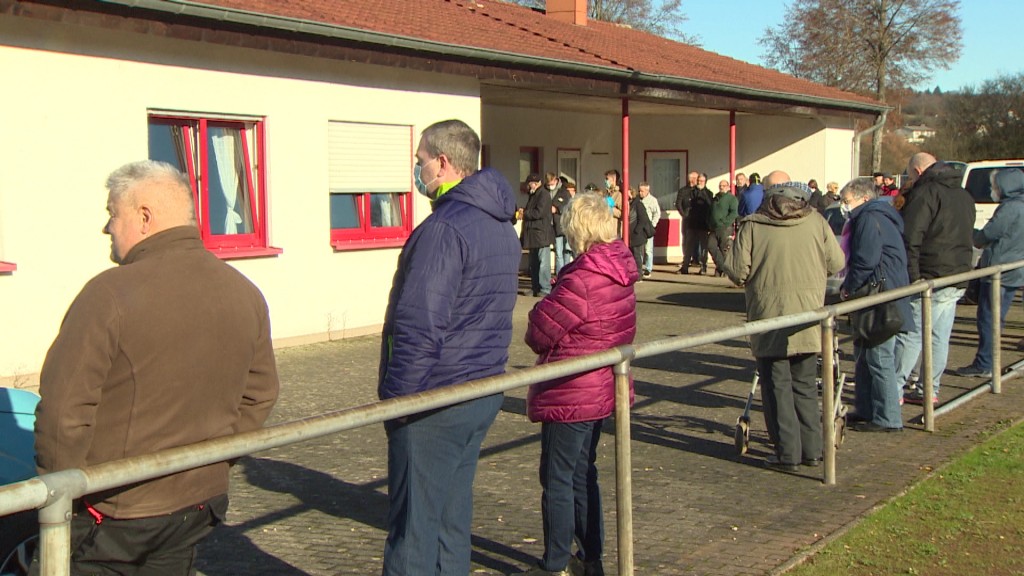 Foto: Menschen stehen für eine Corona-Impfung in einer Schlange vor dem Sportheim in Gersheim