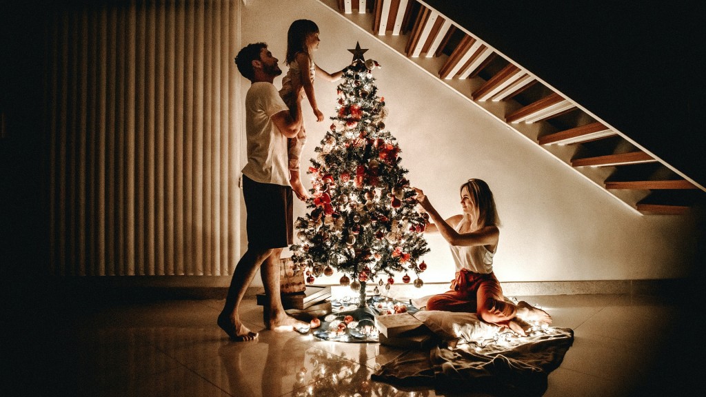 Symbolbild: eine dreiköpfige Familie schmückt einen Weihnachtsbaum (Foto: pixabay (CC0))