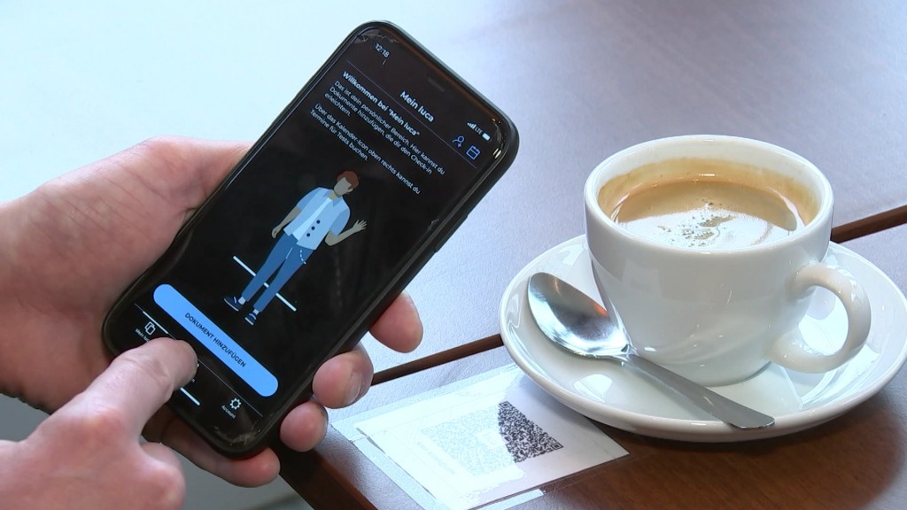 Foto: Person lockt sich im Café in der Luca-App mittels QR-Code ein 