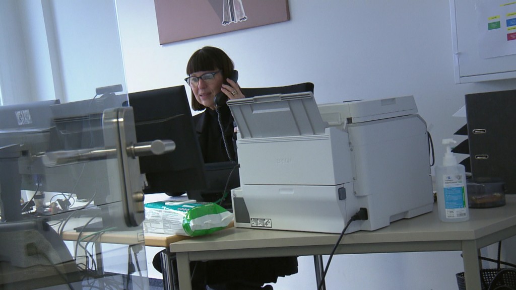 Foto: Mitarbeiterin des Gesundheitsamtes telefoniert an ihrem Arbeitsplatz