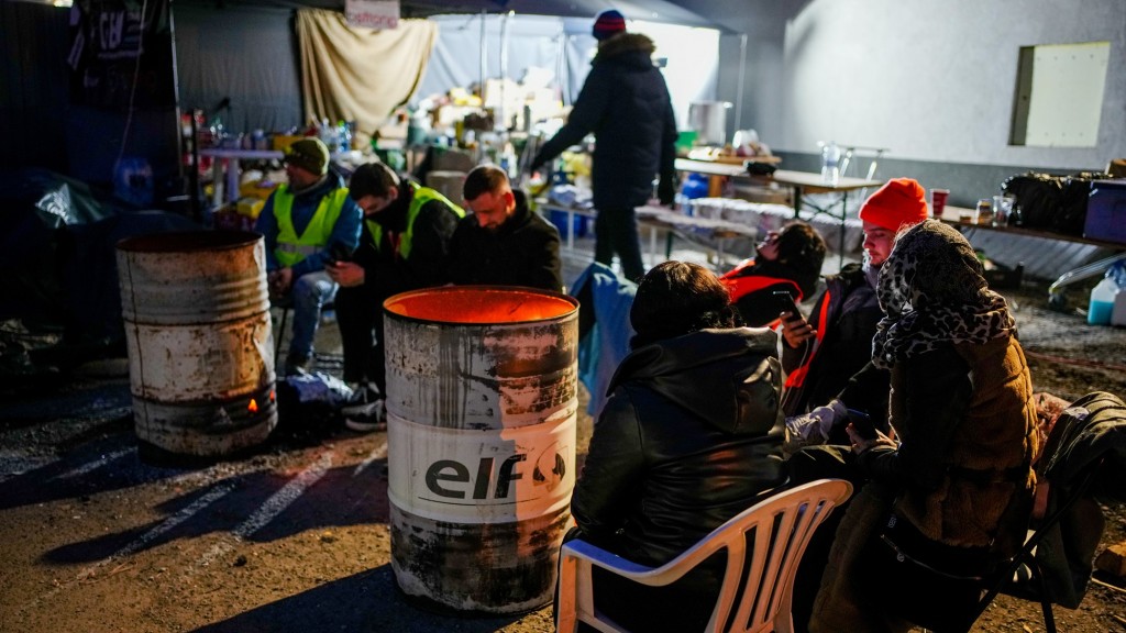 Helfer und Geflüchtete sitzen in einer provisorischen Hilfsstation für Geflüchtete an der ukrainisch-polnischen Grenze in Medyka (Foto: picture alliance/dpa | Kay Nietfeld)