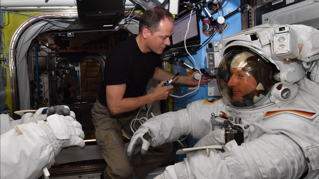 Foto: Vor dem Außeneinsatz wird der Anzug von Matthias Maurer (rechts) kontrolliert. (Foto: picture alliance/dpa/ESA/NASA)