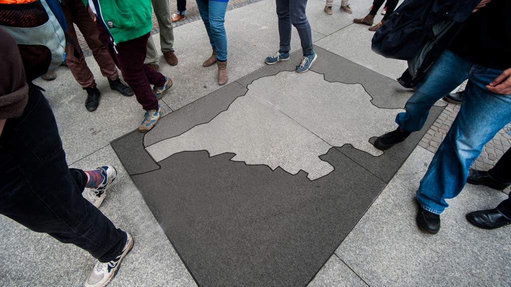 Menschen stehen um aufgemalten Saarlandumriss 