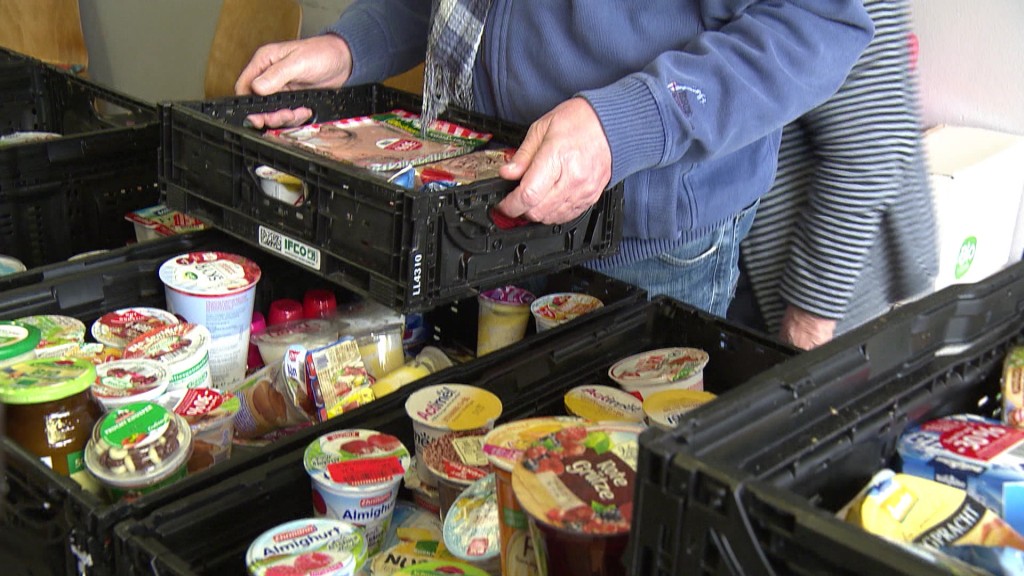 Foto: Personen befüllen Essenskisten der Tafel