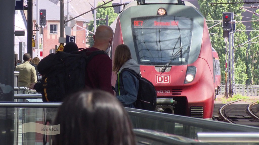 Foto: Menschen warten am Bahnsteig auf einen Zug