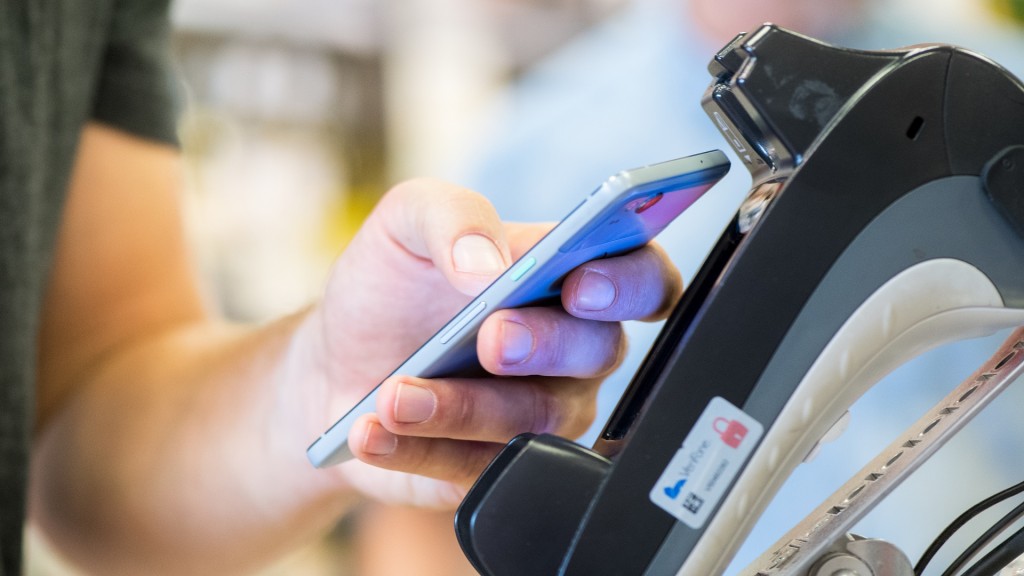 Kontaktloses Bezahlen. Ein Smartphone wird an ein Kassenterminal gehalten.