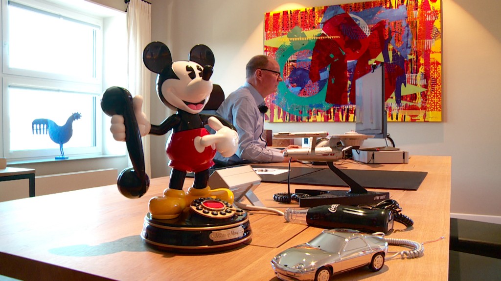 Foto: Eine Micky Mouse Figur mit einem Telefonhörer auf einem Büroschreibtisch