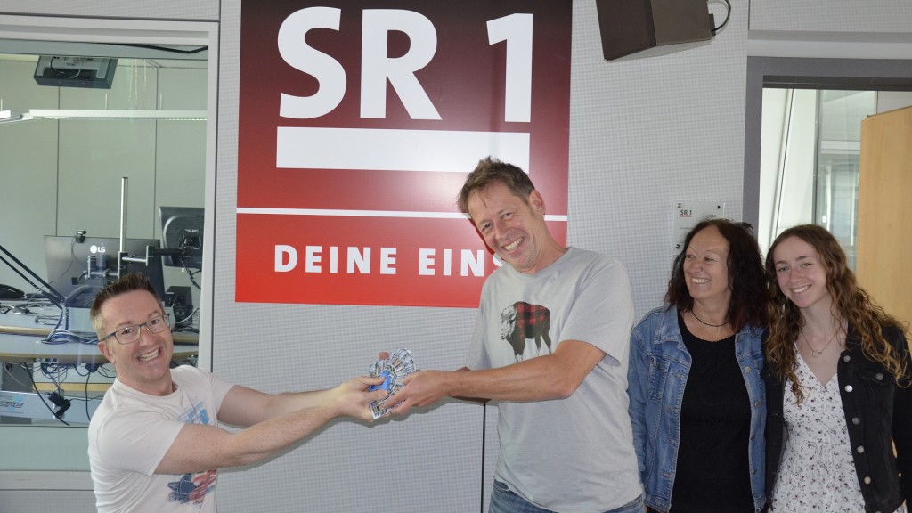 Foto: SR 1-Gib 8-Gewinner Markus Lehnen und seine Familie mit SR 1-Moderator Christian Balser