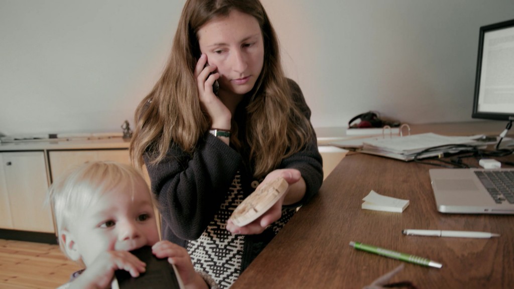 Foto: Eine Frau die sich während der Arbeit noch um die Kinderbetreuung kümmert.