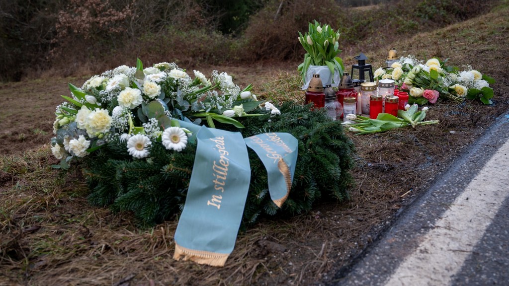 Ein Kranz sowie Blumen und Kerzen liegen am Tatort an der Kreisstraße 22 bei Ulmet (Rheinland-Pfalz) zum Gedenken