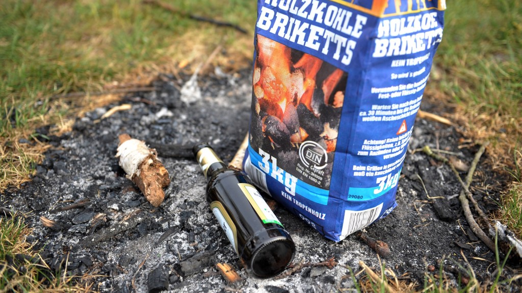 Ein verschmutzer Grillplatz - Holzkohle und Bierflaschen wurden einfach zurückgelassen
