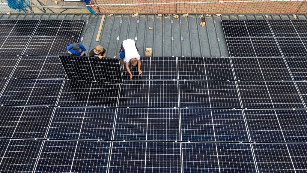 Foto: Solarmodule werden großflächig auf einem Dach montiert