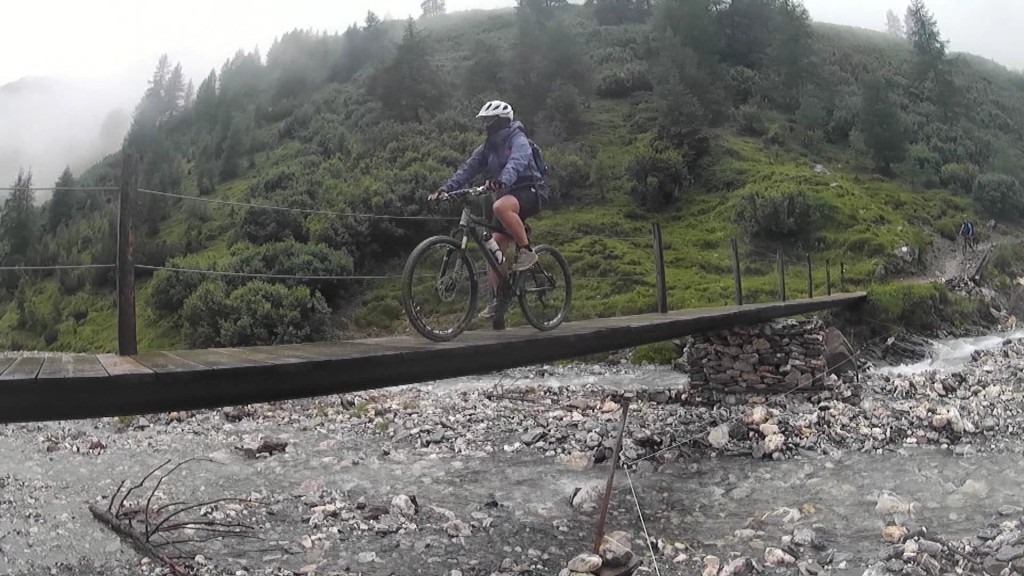 Ein Radfahrer überquert einen Gebirgsfluss