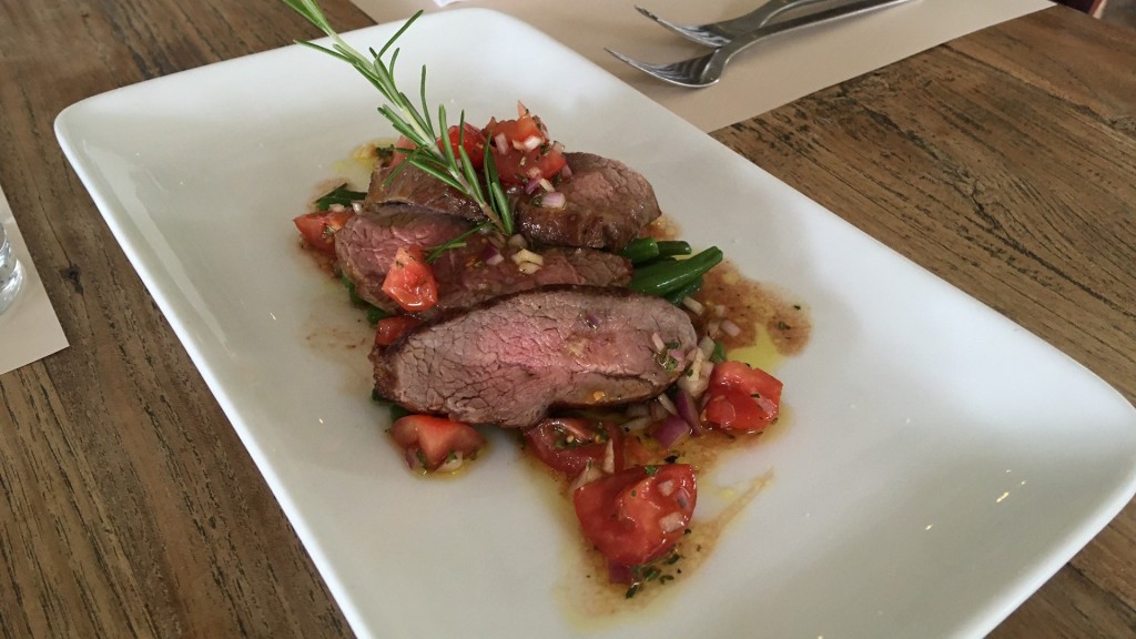 Lamm-Tranchen auf Kräutertomaten und grünen Bohnen