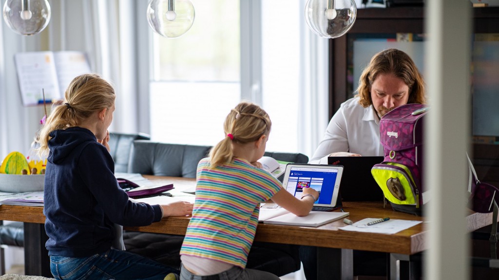 Vater mit zwei Töchtern beim Homeschooling