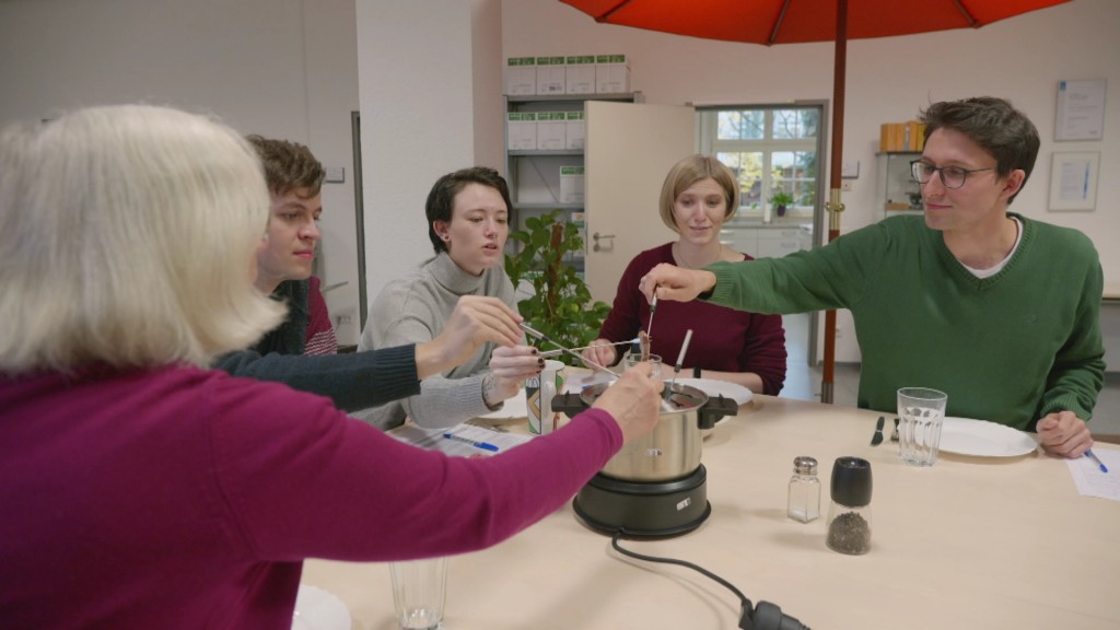 Foto: Menschen am Eßtisch mit Fondue-Gerät 