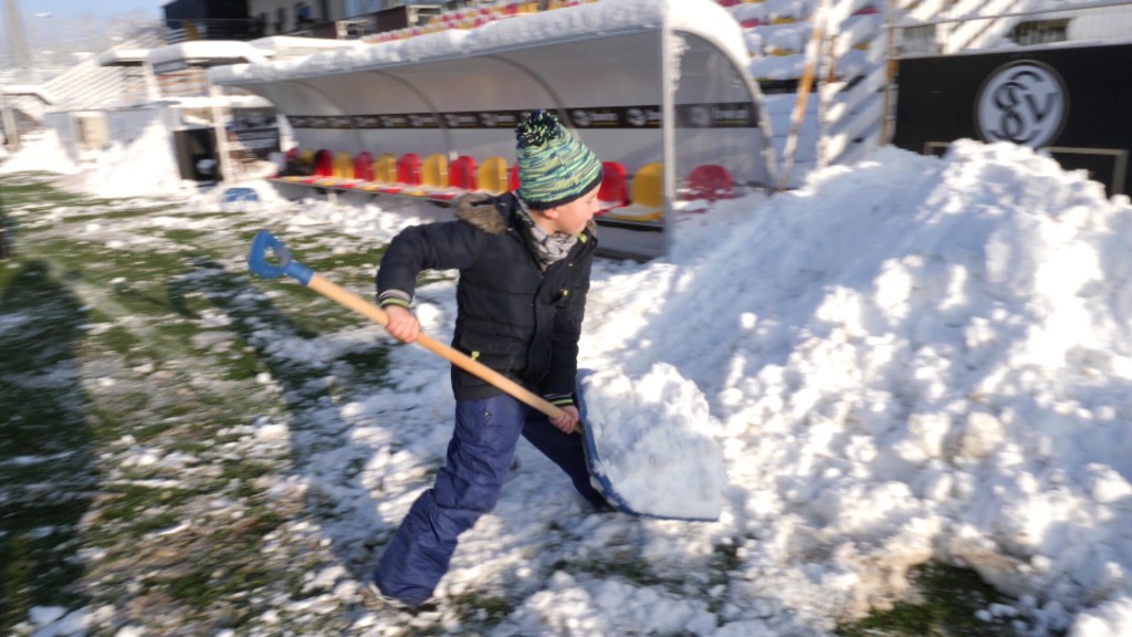 Foto: Junger SVE-Fan hilft bei der Aufräumaktion nach Schneechaos auf dem Spielfeld