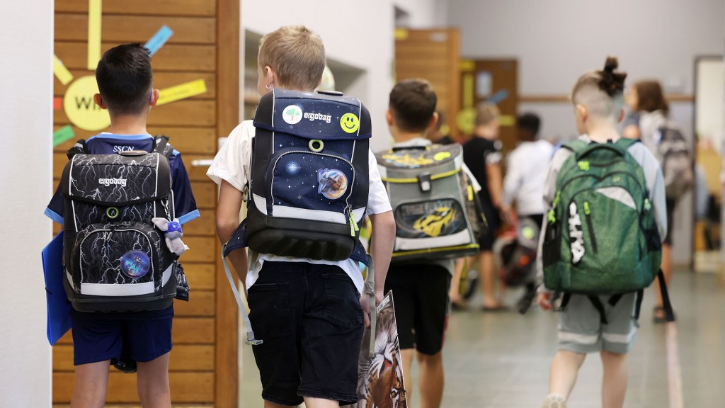 Foto: Grundschüler gehen mit ihren Schulränzen zum Unterricht
