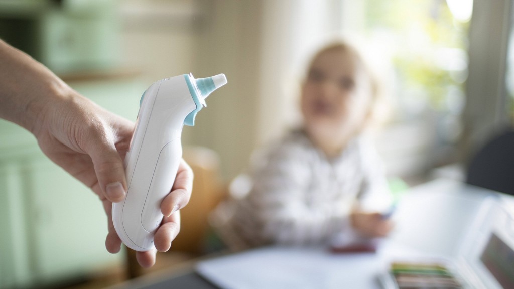 Foto: Eine Hand hält ein modernes Fieberthermometer
