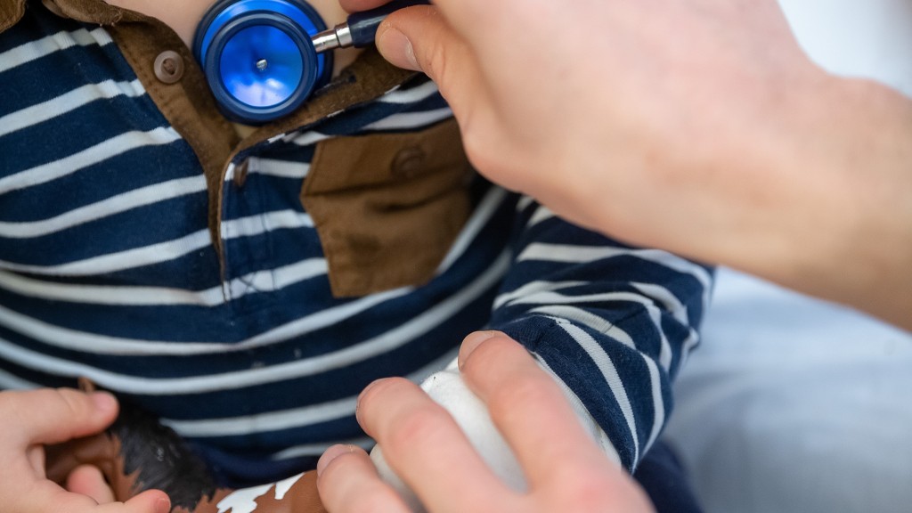 Ein Arzt untersucht ein Kind mit einem Stethoskop. 