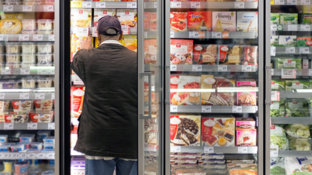 Ein Mann steht vor dem Tiefkühlregal im Supermarkt