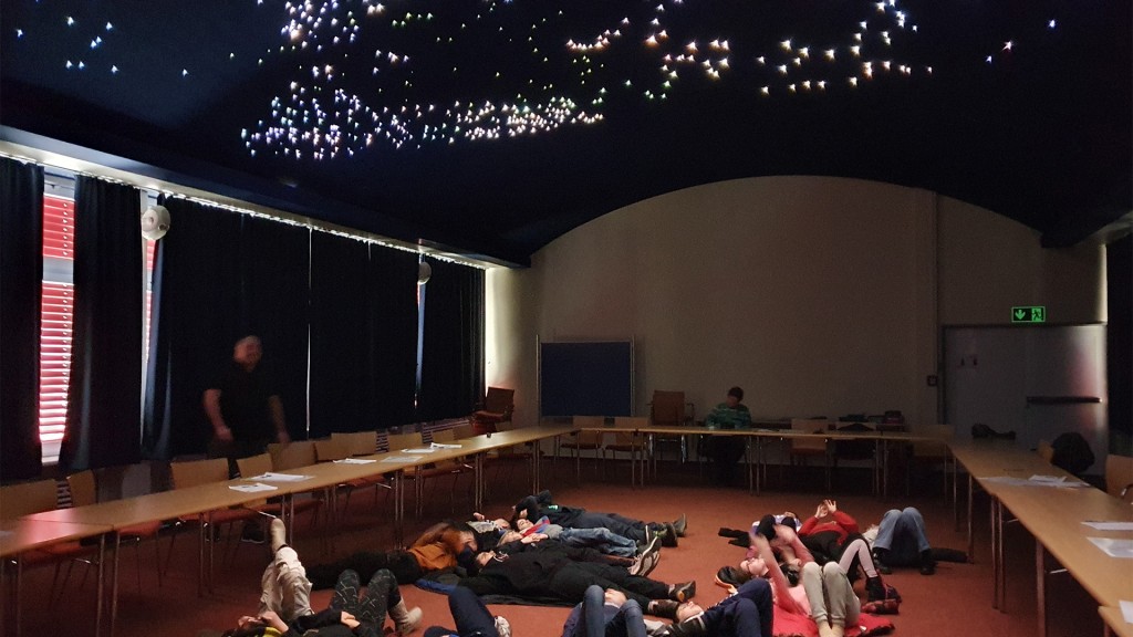 Schüler beobachten einen simulierten Sternenhimmel 