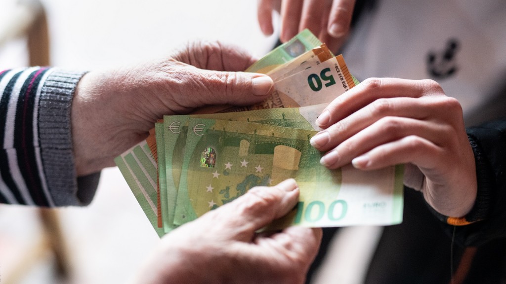 Eine junge Frau lässt sich von einer älteren Dame mehrere hundert Euro an einer Haustür geben.