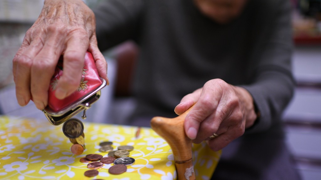 Eine Rentnerin schüttet den Inhalt ihres Geldbeutel auf den Küchentisch. 