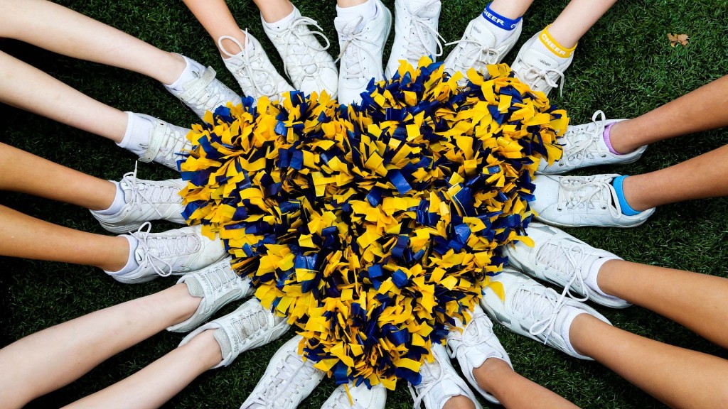 Beine mit Tennisschuhen umrahmen ein Herz aus Cheerleader-Pompoms