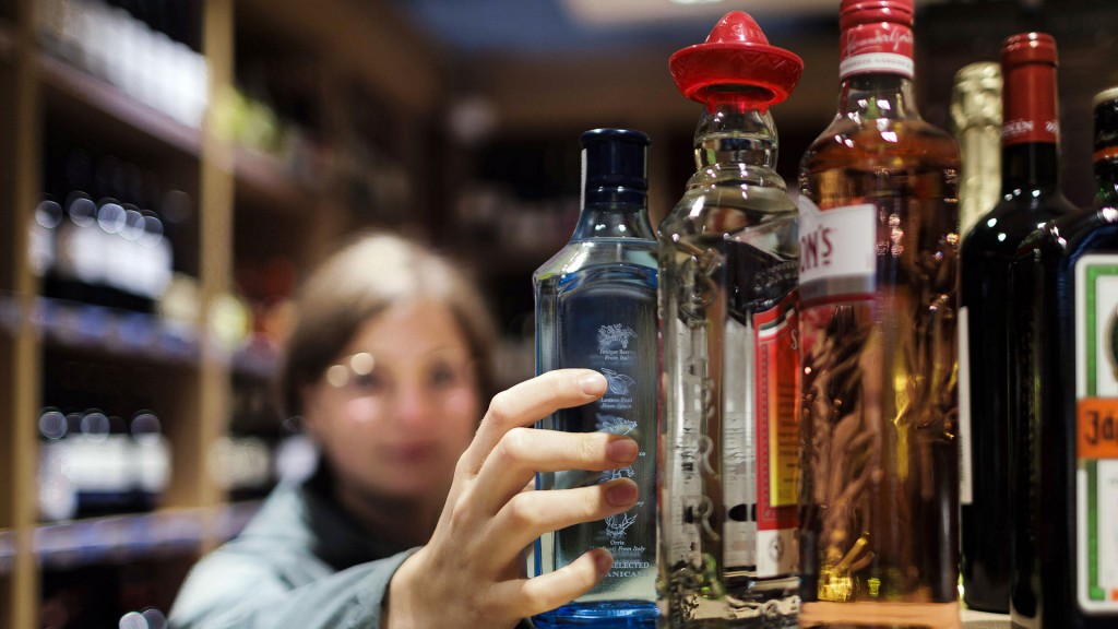 Foto: Eine Junge Frau kauft greift im Supermakt nach alkoholischen Getränken