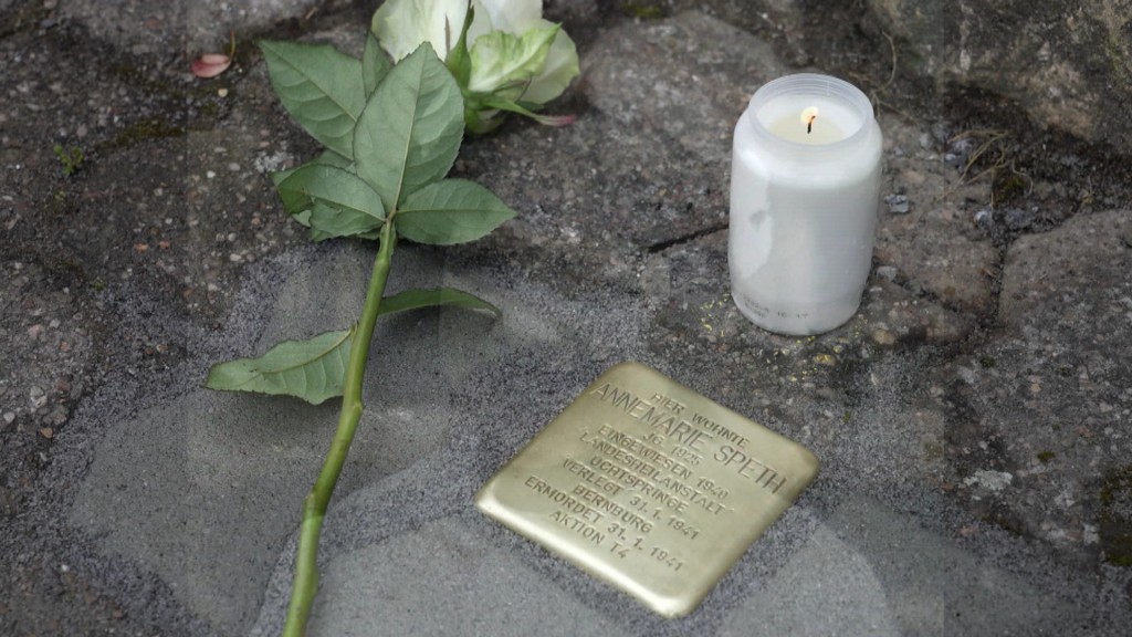 Foto: Ein Stolperstein mit einer Rose