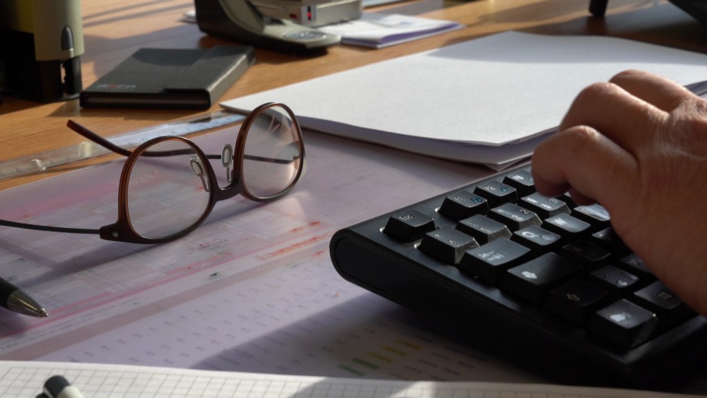 Brille liegt auf dem Schreibtisch neben einer Tastatur