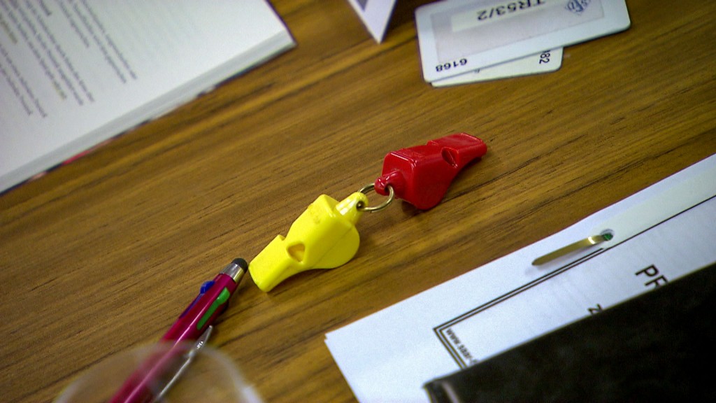 Foto: Eine rote und eine gelbe Schiedsrichterpfeife liegen auf dem Tisch