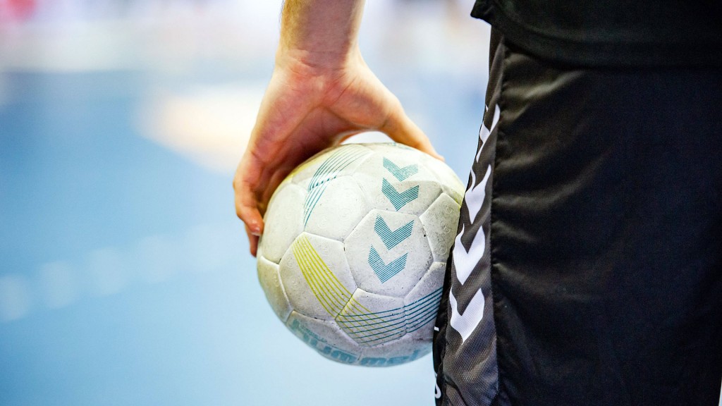 Foto: Ein Mann hält einen Handball auf dem Spielfeld