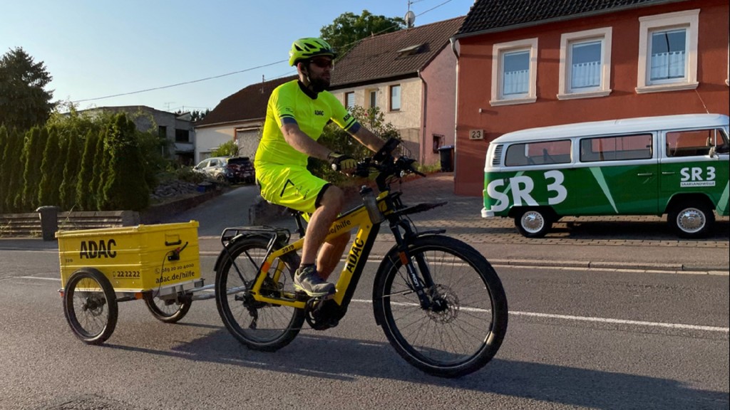 Pannenhelfer Benjamin Becker auf seinem gelben ADAC Fahrrad 